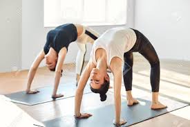 Two Young Women Doing Yoga Asana Upward Bow Wheel Pose Urdhva Stock Photo Picture And Royalty Free Image Image 60824841