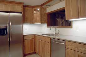 A mirrored grey backsplash, a white marble countertop and appliances that match this. Refacing Vs Replacing Kitchen Cabinets