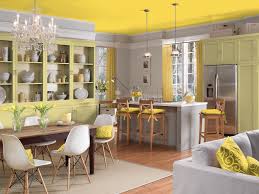 The yellow walls host a gallery of colorful art, and a deep blue sofa holds plenty of patterned pillows. Yellow Color Palette Yellow Color Schemes Hgtv
