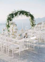 Cliffside Blue And White Wedding In Picturesque Santorini Ruffled White Weddings Reception Santorini Wedding Venue Wedding Arch Greenery