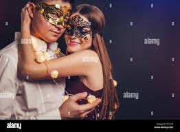 Young couple celebrating New Year's eve covered with a garland on masquerade  party Stock Photo - Alamy