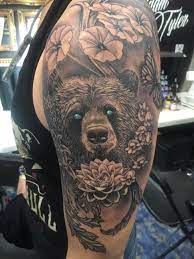 From the indigenous symbols dominating the tattoo flashes in the early years of the traditional american tattoo style, all the way to elaborate realistic pieces today, this aesthetic and symbolics are an important influence with elaborate meanings. Bear And Flowers Tattoo By Dan Limited Availability At Revival Tattoo Studio Bear Tattoo Designs Tattoos Body Art Tattoos