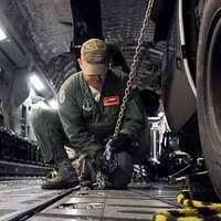 Sgt. Kyle Selman, bottom, and Cpl. Benjamin Cervantes rivet brackets into  the engine space of an F/A-18C Hornet.