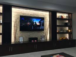 The cabinets hide all the electronic equipment.©finished basement company. Tv Wanden Basement Living Rooms Niche Design Basement Design