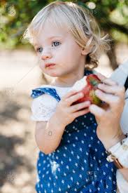 The story of two stubborn idiots wherein they learn that love and ambition come with a lot of pain and sacrifices. Little Girl With Blonde Hair And Blue Eyes Eating An Apple Stock Photo Offset