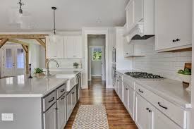 You won't go wrong with adding new shaker cabinet doors to existing kitchen cabinetry either. Open Kitchen With White Shaker Cabinets Gray Island Farmhouse Sink White Quartz Cou White Shaker Kitchen White Shaker Cabinets White Shaker Kitchen Cabinets