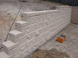 Masonry retaining walls are built with a reinforced concrete base as an anchor and a wall of hollow concrete blocks reinforced with 12mm steel bars. Australian Retaining Walls Heron Concrete Block Retaining Wall Coomera Australian Retaining Walls