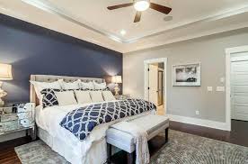 Master Bedroom With Light Gray Walls And Dark Blue Accent Wall Behind Tufted Bed Blue Master Bedroom Master Bedroom Accents Remodel Bedroom