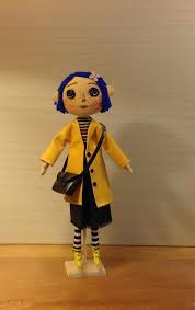 Textile Art Doll Coraline With Her Button Eyes Blue Hair And Yellow Raincoat This Decorative Fabric Doll Is Coraline Doll Textile Art Dolls Coraline Movie