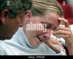 Caitlin Atwater, daughter of Kathleen Peterson, is comforted by her father, Fred  Atwater, during Michael Peterson's murder trial Thursday, July 17, 2003, in  Durham, N.C., after she broke down in tears during the display of  photographs of disputed valuables in ...