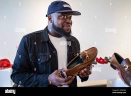 Wale Agboola considers a pair of shoes from Robert Sheie's collection at  luxury men's consignment shop Menswear Market