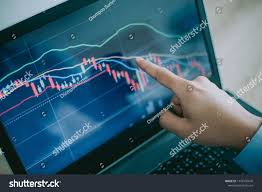 hand of man point to the laptop show financial market chart