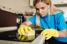Free Photo | Close up of woman wearing in protective glove with rag  cleaning electric stove at home kitchen beautiful girl washing black shiny  surface of kitchen top hand with foam on