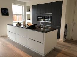 hoge kastenwand zwart gecombineerd met een strak greeploos wit eiland keuken ideeen modern keuken ontwerpen keuken idee