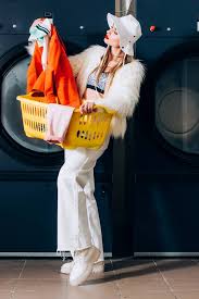 Maybe you would like to learn more about one of these? Stylish Young Woman In Faux Fur Jacket And Hat Holding Basket And Looking At Laundry Near Washing Machines In Laundromat Free Stock Photo And Image