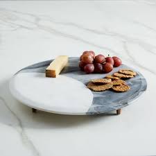 Each cheese board features handcarved mango wood complemented by lustrous white marble. Marble Copper Footed Cheese Board