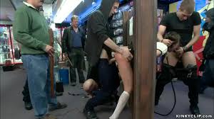 Sexy brunette doll Riley Reid is public d. by mistress Chanel Preston then  made to gangbang fuck by big cock Xander Corvus and stranger while she is  locked in stock wall -