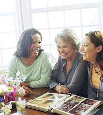 Woman laughing in a social group while subtly trying to stay composed
