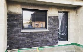 Un Parement En Pierre Orsol Pour Habiller L Entree D Une Maison Aux Volumes Modernes Parement En Plaque Rocky Mountai Maison Construction Maison Brique Noire