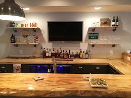 As the support of the countertop, there's a rustic wall which is made of stone which is designed in a certain pattern to give a balanced atmosphere into the bar. Photos Of Wet Bars In Basement Remodels