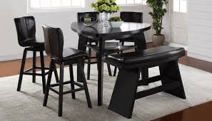 This contemporary dining room has a black triangle dining table with some white leather dining chairs and bench. Triangle Mesa Alta 2 Taburetes Y Un Banco Mesas De Vidrio Comedor Mesas De Comedor Negras Bar Comedor