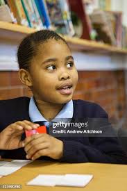 A young African schoolgirl looks at her teacher to answer a question...  News Photo