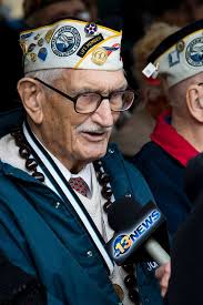 John Delia, a Pearl Harbor survivor, is interviewed by a reporter from  WVEC, 13 News in Norfolk, at a Pearl Harbor Remembrance Ceremony at Joint  Expeditionary Base Little Creek-Fort Story.