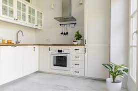This bright kitchen's wood floors complement the cabinetry and the tile used in the workspace of the kitchen well. Pros And Cons Of Marble Flooring In Kitchens