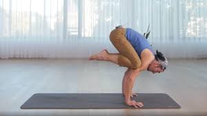 Smiling male yogi practicing crane pose isolated on white. Crow Bakasana A Yoga Pose To Overcome Fears Tint Yoga