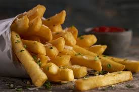 Desk with leather desk pad, walnut desk organizer, wireless keyboard and mouse, and porcelain mug.