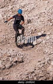 The well-known alpine unicyclist Michael Rung in the Karwendel mountains at  over 2300 m height with his unicycle Stock Photo