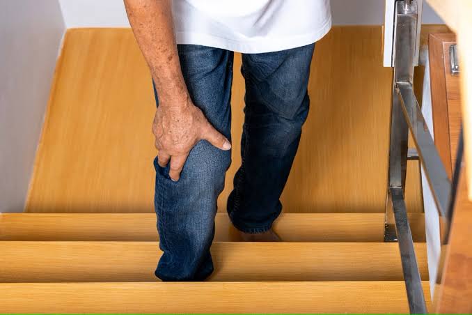 Senior patient climbing stairs with knee pain