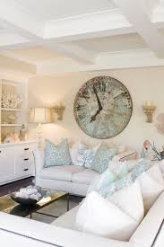 White walls and contemporary furniture give this living room a clean and classic feel. Large Wall Clocks Make A Statement Wall Art Wall Decor Living Room White Living Room Beach House Interior Design Coastal Living Rooms Beach House Interior