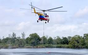 Firefighters carry out water bombing on raging peatland fire