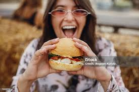 Street Food Festival Stylish Hipster Girl In Sunglasses Eating Delicious  Vegan Burger At Street Food Festival Happy Boho Woman Tasting And Biting  Burger With Vegetables In Summer Street Stock Photo