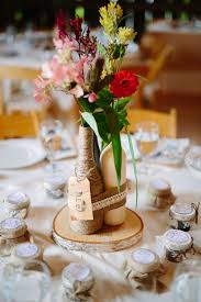For one thing, if you use the bottles as vases, their height makes it tricky to achieve a balanced look with a full bouquet. Diy Rustic Wine Bottle Centerpiece