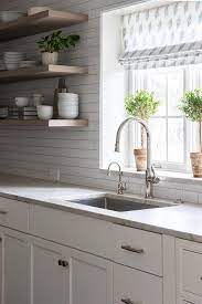 A background of vibrant yellow tiles framed by cream subway tiles is a guaranteed way to make a sunny statement in the bathroom. Marble Clad Windowsill With Topiaries Transitional Kitchen