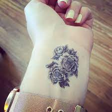 Peony is a strong symbol of beauty, fragility and transitory nature of existence. Black Ink Peony Flowers Tattoo On Girl Left Wrist