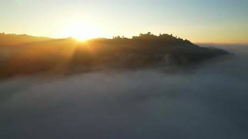 Vista aérea de 4K voando na neblina. O sol está escondido atrás das nuvens na neblina do pôr do sol., Banco de filmagens Incluindo: colina e chuva - Envato