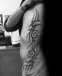 The tribal design carved on the ribs goes well with the contours and looks simply stunning. Top 40 Best Tribal Rib Tattoos For Men Manly Ink Design Ideas