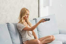 Members of big family looking at mature blonde woman with glass of wine making christmas toast by festive dinner. Charmante Blonde Frauen Sitzen Auf Bequemen Sofa Mit Nackten Beinen Und Hoschen Fernsehen Und Andern Kanal Mit Fernbedienung Lizenzfreie Fotos Bilder Und Stock Fotografie Image 33122993