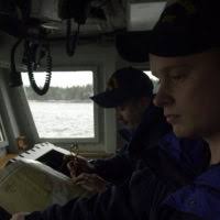 US Coast Guard SEAMAN Jonathan Trusty and US Coast Guard SEAMAN John  Kinstrey pull the lines of the boat so that the US Coast Guard cutter  NAUSHON can get closer to the