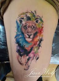 This Illustrative Style Tattoo Features An Abstract Lion Head Splashed Across The Back Of The Bicep The Sk Watercolor Lion Tattoo Mens Lion Tattoo Lion Tattoo