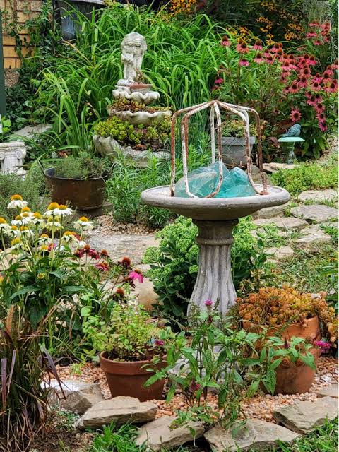 Bird bath next to container garden