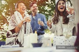 Portrait of two friends laughing loud together during a conversation sitting on a couch in the living room at home. Friends Laughing And Drinking Champagne At Birthday Party Four People Women Stock Photo 200689718