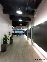 Build a basement light well. Corridor In An Office Space With Black Laminate Accent Wall With Light Coves Exposed Ceili Exposed Ceilings Basement Bathroom Ceiling Ideas Basement Lighting