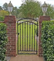 Coloring wrought iron can highlight the design and make the fencing really pop. Tall Donovan Wrought Iron Gate Hung On Brick Pillars