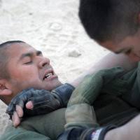 U.S. Marine Corps Marines (Left to Right) CPL. John Huether (left) and SGT.  Penate Vasquez, both of 1ST Force Service Support Group (1FSSG), sit in  position to grapple at Marine Corps Martial