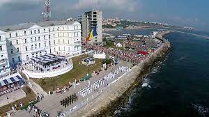 Pe faleza din constanţa, sute de oameni aflaţi la plimbare, mai puțini ca în alți ani, în această frumoasă zi de vară admiră defilarea navelor militare desfășurate la 2 mile depărtare de ţărm, cu ocazia zilei marinei române, o zi sărbătorită altfel în acest an, din cauza pandemiei de coronavirus. Ziua Marinei Romane Maine Are Loc La ConstanÈ›a Cel Mai Amplu Spectacol Naval Al Anului Vezi Aici Programul