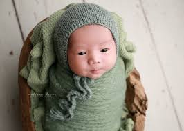 Baby swaddled in green